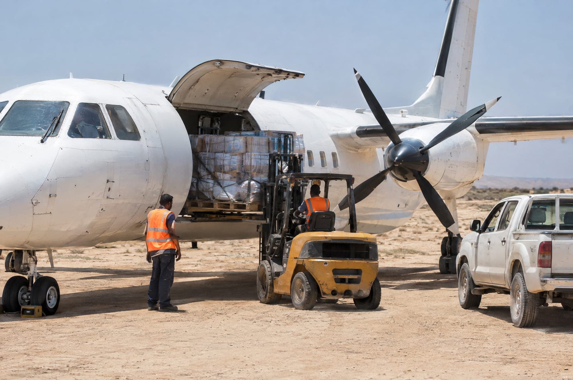 Illustration: a cargo plane being loaded on an airstrip