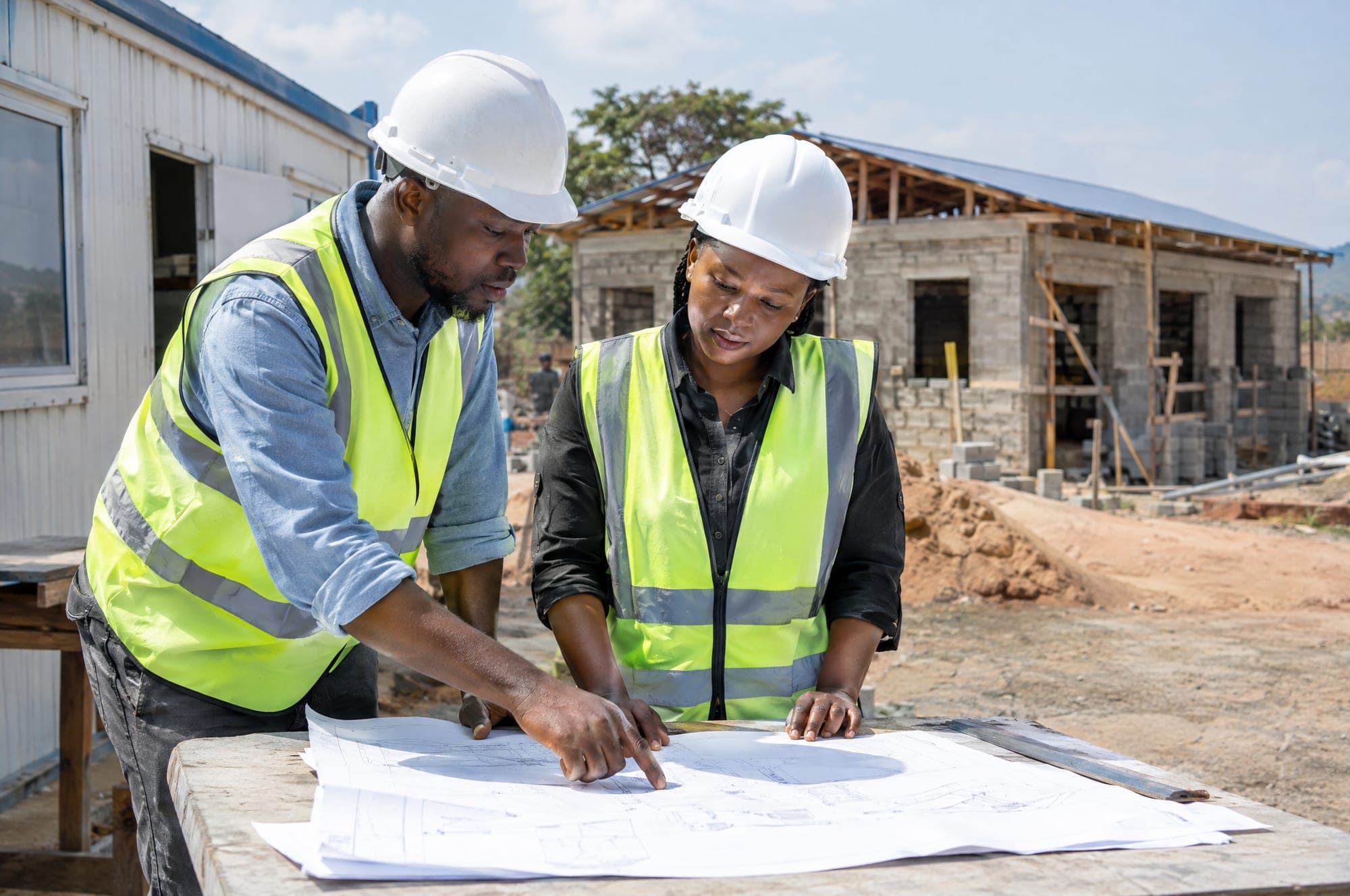 Illustration: an engineer and a project manager reviewing drawings in a site office