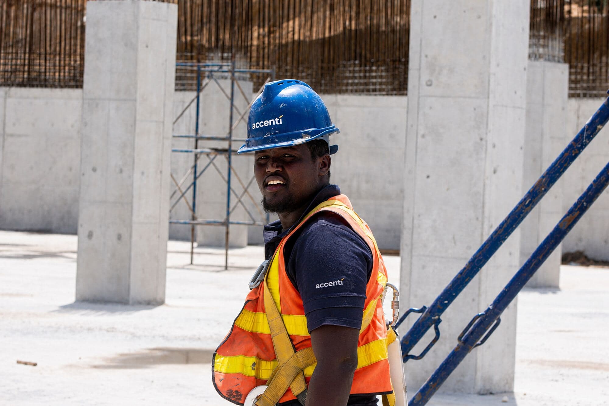 Accenti site staff member in PPE beside concrete columns