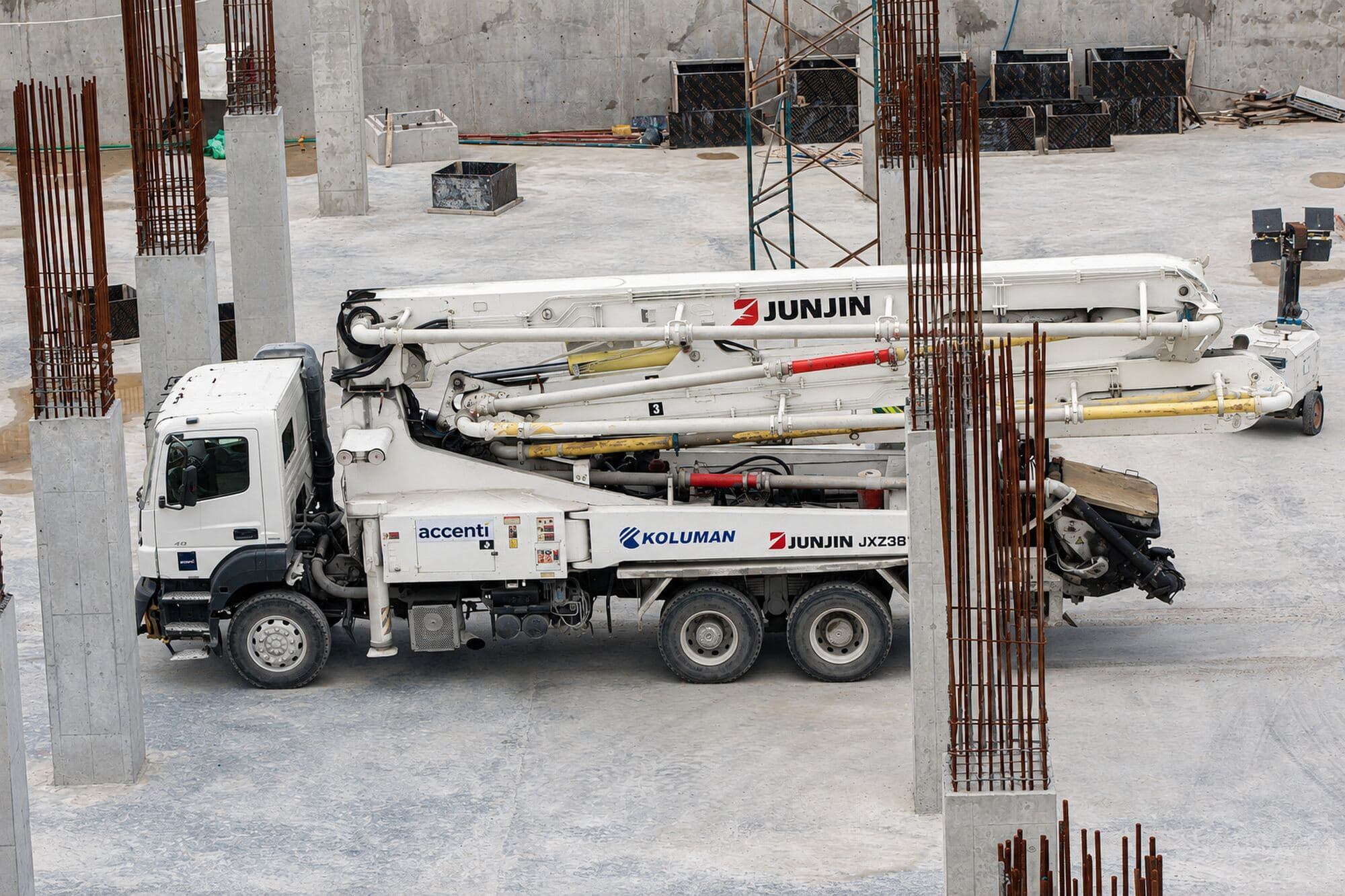 Truck-mounted concrete boom pump on site