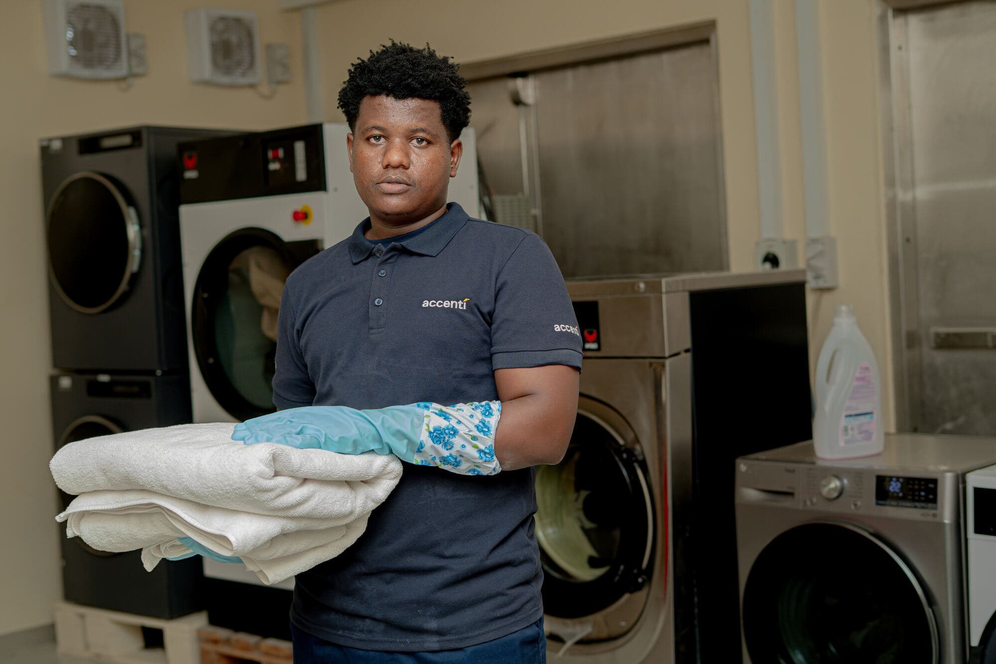Accenti laundry team member with folded linen