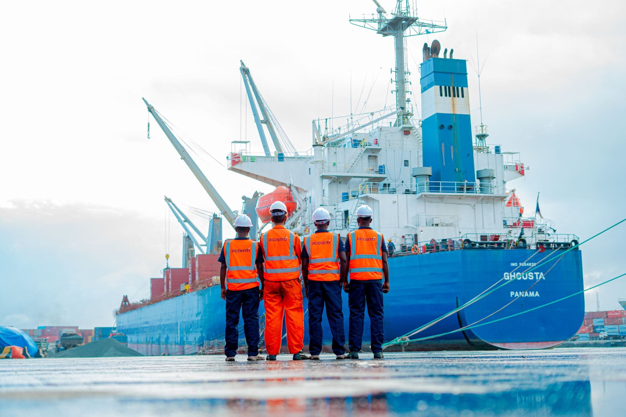 Accenti port team on the quayside facing a cargo vessel in Mogadishu