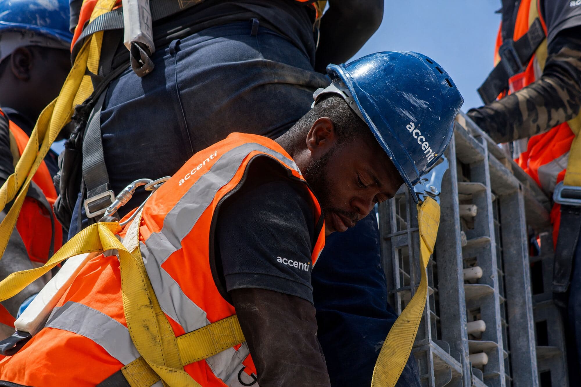 Accenti crew member wearing a fall-arrest harness on site